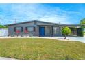 Inviting single-story home with a manicured lawn, decorative rock landscaping, modern accents and a bright blue front door at 4409 Maceachen Blvd, Sarasota, FL 34233