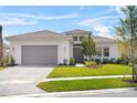 Beautiful single-story home with a gray tile roof, paver driveway, and manicured lawn at 4711 Cedron Ct, Sarasota, FL 34240
