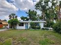 Inviting one-story residence with a blue front door, lush greenery, and a well-kept lawn at 4712 Cronin Dr, Sarasota, FL 34232