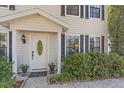 Inviting front entrance with decorative door, manicured bushes, and black window shutters at 5766 Forester Pine Ct, Sarasota, FL 34243