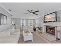 Bright living room featuring a fireplace, ceiling fan, and neutral decor at 5766 Forester Pine Ct, Sarasota, FL 34243