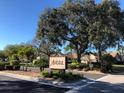 Avista community sign with mature oak trees, well manicured landscaping, and blue sky background at 5767 Avista Dr # 5767, Sarasota, FL 34243