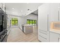Modern kitchen with white cabinets, a large center island, and sleek appliances at 5838 Meriwether Pl, Sarasota, FL 34232