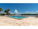 Inviting pool area with lounge chairs, lush landscaping, and serene waterfront views at 605 Sutton Pl # 401-A, Longboat Key, FL 34228