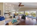 Bright living room with ceiling fans, vaulted ceiling, hardwood floors and sliding glass doors to the deck at 612 Fern St, Anna Maria, FL 34216