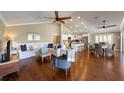 Bright living room with ceiling fans, vaulted ceiling, hardwood floors with kitchen in the background at 612 Fern St, Anna Maria, FL 34216