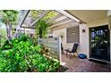 Charming front entrance with a covered patio, adorned with a sun decoration, plants, and seating at 631 Woodlawn Dr, Bradenton, FL 34210