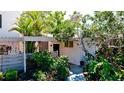 Inviting front entrance featuring a pergola, lush tropical foliage, and a charming walkway at 631 Woodlawn Dr, Bradenton, FL 34210