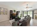 Comfortable living room featuring tile flooring, neutral paint, ceiling fan, and large windows at 6723 Trent Creek Dr, Sun City Center, FL 33573