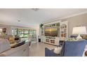 Inviting living room with comfortable seating, built-in shelving, and views of the outdoor patio at 7269 Golf Pointe Way, Sarasota, FL 34243