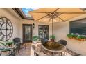 Charming patio space with brick flooring, outdoor furniture, decorative plants, and a stylish umbrella at 7269 Golf Pointe Way, Sarasota, FL 34243