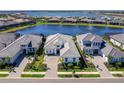 An aerial shot showcases a luxurious home with a lake view and well-maintained landscaping at 8335 Sea Glass Ct, Sarasota, FL 34240