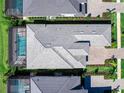 An aerial view shows the roof, landscaping, and screened-in pool of the home at 8335 Sea Glass Ct, Sarasota, FL 34240