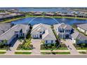 An aerial shot showcases a luxurious home with a lake view and well-maintained landscaping at 8335 Sea Glass Ct, Sarasota, FL 34240