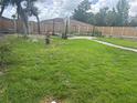 Spacious backyard featuring a well-maintained lawn, wooden fence, and a cozy brick fire pit area at 8419 Sylvan Woods Dr, Sarasota, FL 34243