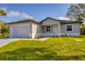 Charming single-story home featuring a two-car garage, well-manicured lawn, and welcoming curb appeal at 102 Arrow Ln, Rotonda West, FL 33947