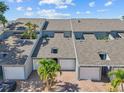 Exterior view of townhomes featuring multi-car garages, modern roofing, and mature palm trees at 1233 Dockside Pl # 207, Sarasota, FL 34242