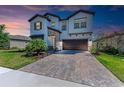 Beautiful two-story home featuring a brick driveway, manicured lawn, and a two-car garage at 12664 Oak Hill Way, Parrish, FL 34219