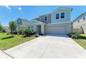 Two-story home featuring a concrete driveway, well-kept lawn, and a two-car garage at 12738 Hysmith Loop, Parrish, FL 34219