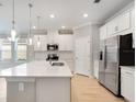 Modern kitchen with white cabinets, stainless steel appliances, and a center island with quartz countertops at 1596 Laurel Brook Ln, Port Charlotte, FL 33953