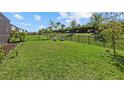 Expansive backyard features lush green grass, a wrought iron fence and lounge chairs at 16226 Paynes Mill Dr, Bradenton, FL 34211