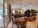 Dining room with a table for six and a view through sliding glass doors to the pool area at 193 Montelluna Dr, North Venice, FL 34275