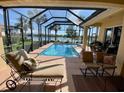 Outdoor screened-in pool with patio, lounge chairs, and views of the surrounding landscaping and lake at 193 Montelluna Dr, North Venice, FL 34275