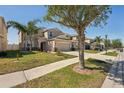 Charming two-story home with well-manicured lawn, large driveway, and mature shade trees at 2332 Dovesong Trace Dr, Ruskin, FL 33570