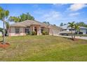 Beautiful single-story home with lush green lawn, well-maintained landscaping, and a boat on the driveway at 2396 Malibu Ln, North Port, FL 34286