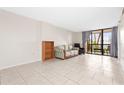Bright living room with tile floors, comfortable seating, and sliding glass doors to balcony at 3006 Caring Way # 210, Port Charlotte, FL 33952