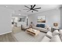 A stylish living room featuring neutral tones, a ceiling fan, and an open layout flowing into the kitchen at 3169 Bellevue St, Sarasota, FL 34237