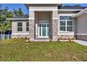 Close up of covered entry featuring stone accents and a contemporary glass door at 3694 Crittendon St, North Port, FL 34286