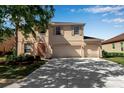 Two-story home featuring a three car garage, balcony, manicured lawn and lush landscaping at 4007 61St E Dr, Bradenton, FL 34203