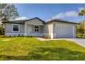 Charming single-story home with manicured lawn and an attached two-car garage at 405 Sunset N Rd, Rotonda West, FL 33947