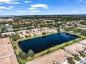 Scenic aerial view showcases a community with houses near a large lake, lush greenery, and blue sky at 4136 Cascade Falls Dr, Sarasota, FL 34243