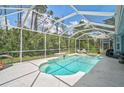 Screened-in pool area with clear blue water, spa, and comfortable seating surrounded by greenery at 4146 Westbourne Cir, Sarasota, FL 34238