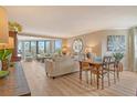 Bright living room features wood floors, neutral tones, a balcony and comfortable seating at 450 Gulf Of Mexico Dr # B207, Longboat Key, FL 34228