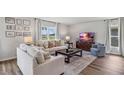 Well-lit living room with wood floors, a sofa, a comfortable chair, and a television at 5026 Rocky Coast Pl, Palmetto, FL 34221