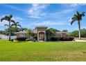 Single-story home featuring lush landscaping, mature palm trees, and a welcoming front entrance at 5209 26Th W Ave, Bradenton, FL 34209