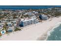 Aerial view of condos featuring beach access, a community pool, and beautiful landscaping at 5300 Gulf Dr # 204, Holmes Beach, FL 34217