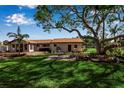 Expansive backyard featuring a beautiful lawn, mature trees, and outdoor seating area, perfect for relaxation at 60 Liles St, Terra Ceia, FL 34250