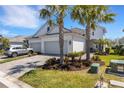 Exterior of home with a two car garage, complemented by well-maintained landscaping and mature palms at 6255 Cassia St, Bradenton, FL 34203