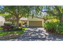 Charming single-Gathering home featuring a two-car garage and mature trees shading the front yard at 6407 Quail Hollow Pl, Bradenton, FL 34210