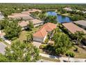 Aerial view of a landscaped home with a paver driveway and a nearby lake at 7159 Westhill Ct, Lakewood Ranch, FL 34202