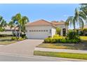Landscaped home featuring an attached two-car garage, tiled roof, and paver driveway at 7159 Westhill Ct, Lakewood Ranch, FL 34202