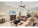 Inviting living room featuring a cozy fireplace, tile flooring, a ceiling fan, and comfortable seating at 8271 47Th Street E Cir, Palmetto, FL 34221