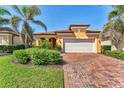 Charming home with a red tile roof, paver driveway and lush tropical landscaping at 10072 Cozy Grove Dr, Venice, FL 34293