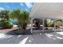 View of the carport with a concrete floor and tropical landscaping at 108 Martin Ne Dr, Port Charlotte, FL 33952