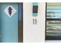A close up on the home's address, a modern metallic sculpture, and the beautifully colored front door at 11 1St E St, Nokomis, FL 34275