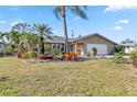 Charming single-story home featuring lush landscaping and a well-maintained lawn at 125 Golf Club Ln, Venice, FL 34293